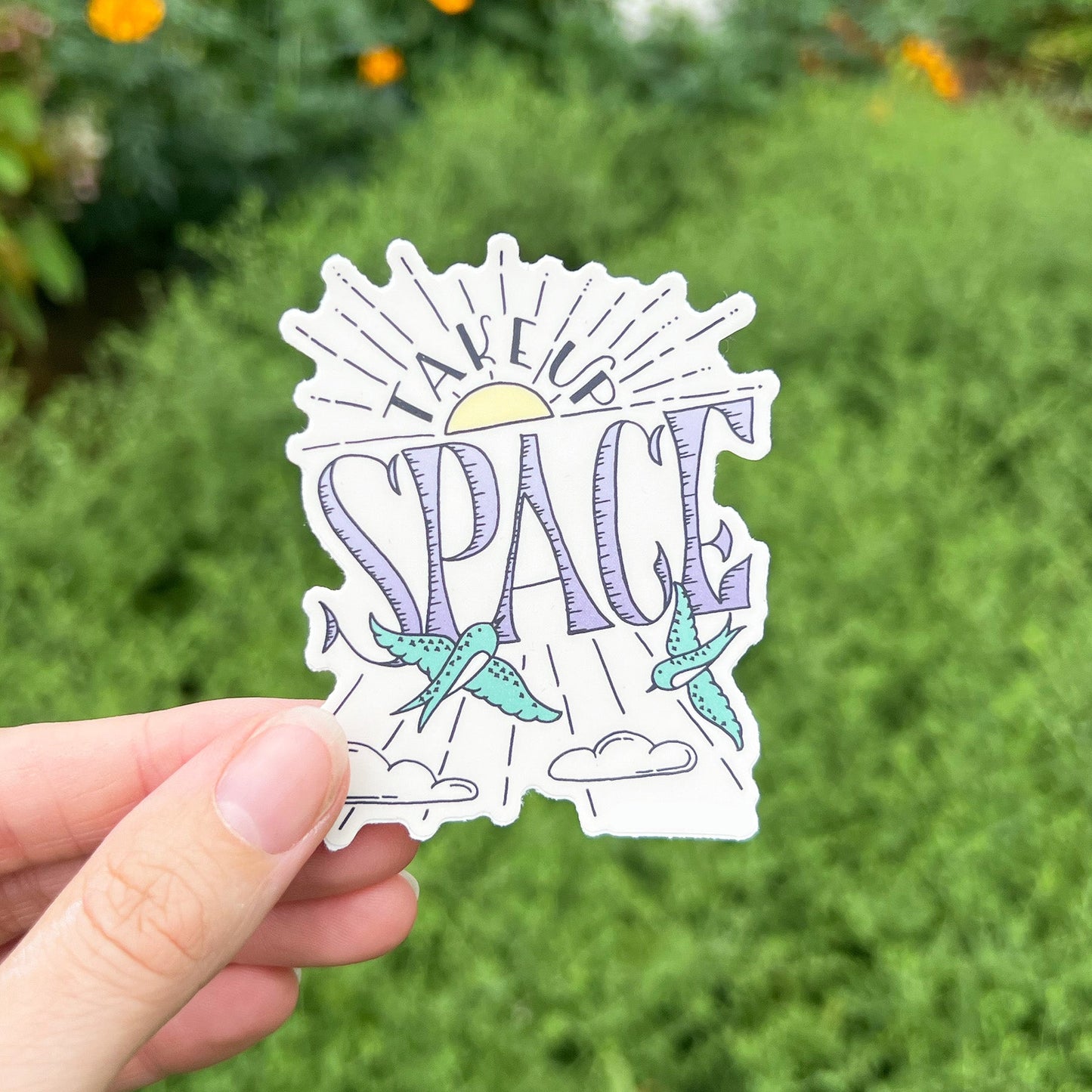 A vinyl sticker with a design that includes the text 'Take Up Space' and illustrations of two butterflies with a sun and clouds background.